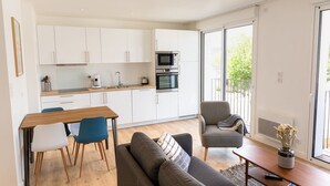 A modern apartment with a kitchen, dining area, and living room. - Port Ste-Marine: L'Escale - Balconies & Small view (Combrit)