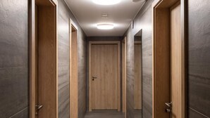 Un couloir avec des portes en bois et un sol carrelé.