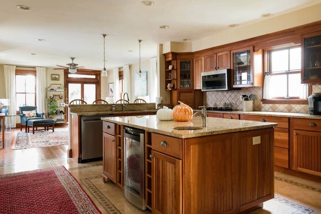 A spacious kitchen with wooden cabinets, a central island, and a built-in microwave.