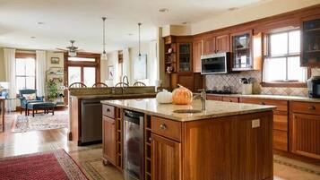 A spacious kitchen with wooden cabinets, a central island, and a built-in microwave.