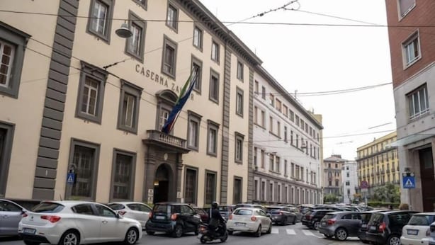 A street with parked cars and a building labeled "CASERMA ZAN." - Molo 5 (Naples)