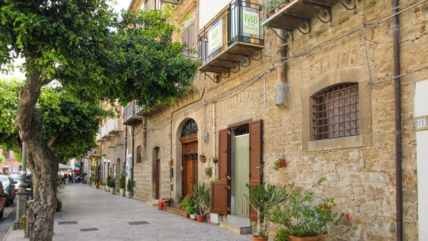 A narrow street lined with stone buildings, some with balconies and potted plants. - THE PALACE B&B and Apartments - FLOWER LUXURY ROOM (Santo Stefano di Camastra)