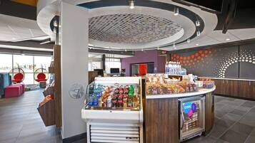 A modern kiosk with a beverage display, a refrigerated section, and a variety of snacks.