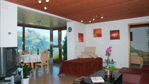 Habitación amplia con cama, zona de comedor y televisor.