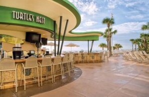 Enjoy a meal at Turtles Nest, where tables face a serene body of water.