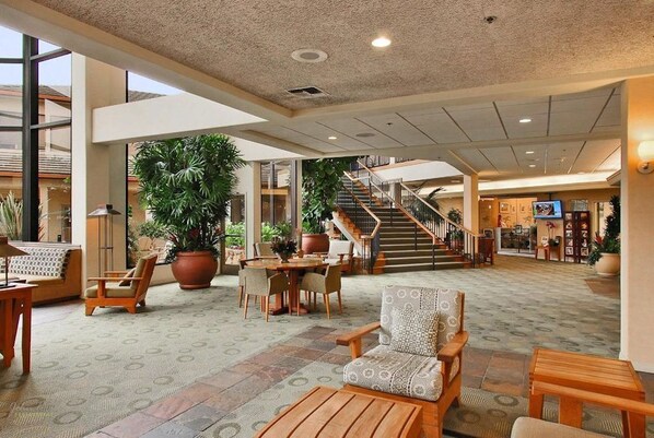 A spacious lobby with a central seating area, large potted plants, and a staircase leading to upper floors. - Seascape Resort in Aptos, Fabulous Ocean View Condo with 2/2.5 and Sleeps 6 (Aptos)