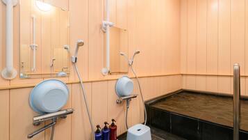 A bathroom with wooden walls, a bathtub, a shower area, and a toilet.