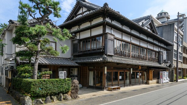 Un edificio japonés tradicional de dos pisos, con vigas de madera y techo de tejas.