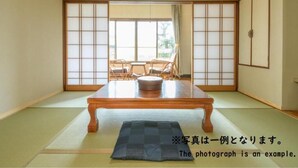 Una habitación japonesa tradicional con suelo de tatami, una mesa de madera baja y puertas correderas shoji.