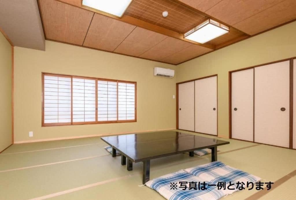 A traditional Japanese room with tatami flooring, a low table, sliding doors, and a shoji screen.