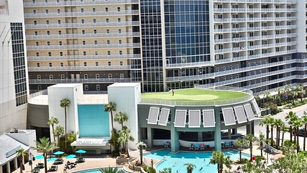Un hotel con un'ampia area piscina, numerosi balconi e un design architettonico moderno.