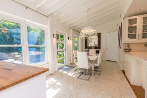 Enjoy meals in the kitchen and dining area, where a large dining table seats four and offers a view of the lush greenery through the patio.
