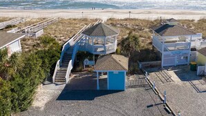 A beachside property with a small building, a covered deck, and a staircase leading to a beach area. - 2 Blocks from Beach, Dog Friendly w/ no dog fees!, Hot Tub, Fenced Yard (Kure Beach)