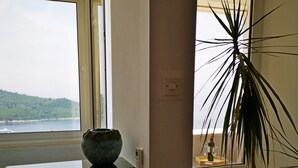 A room with a view of a body of water, a potted plant, and a woven mat on the floor. - Sea View Apartments - Apartment Merivo (Dubrovnik)