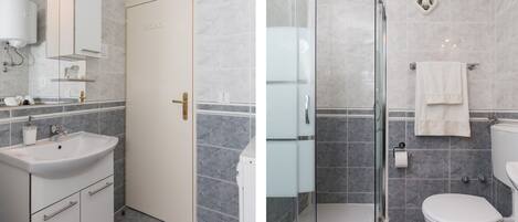 Baño con lavamanos, espejo, inodoro y ducha.