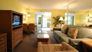 A living room with a television, sofa, chairs, and a dining area. - LOWER LAST MINUTE WEEKDAY PRICE!! Come relax in Destin without the crowds! (Destin)