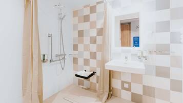 A modern bathroom with a shower, a sink, and a mirror.