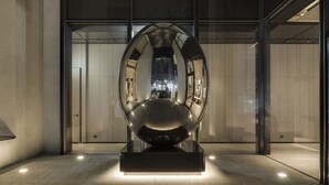 A modern sculpture in a lobby with a glass floor, reflective walls, and a minimalist design. - Hotel Resonance Taipei, Tapestry Collection by Hilton (Taipei)