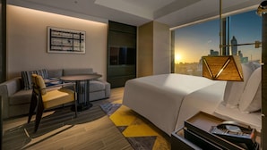 A modern hotel room with a bed, a sofa, a small table, and a city view. - Hotel Resonance Taipei, Tapestry Collection by Hilton (Taipei)