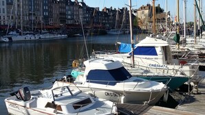 A marina with boats docked, wooden walkways, and buildings in the background. - LA MAISON BALANCOIRE - Private parking - private terrace - La Clé de Honfleur (Honfleur)