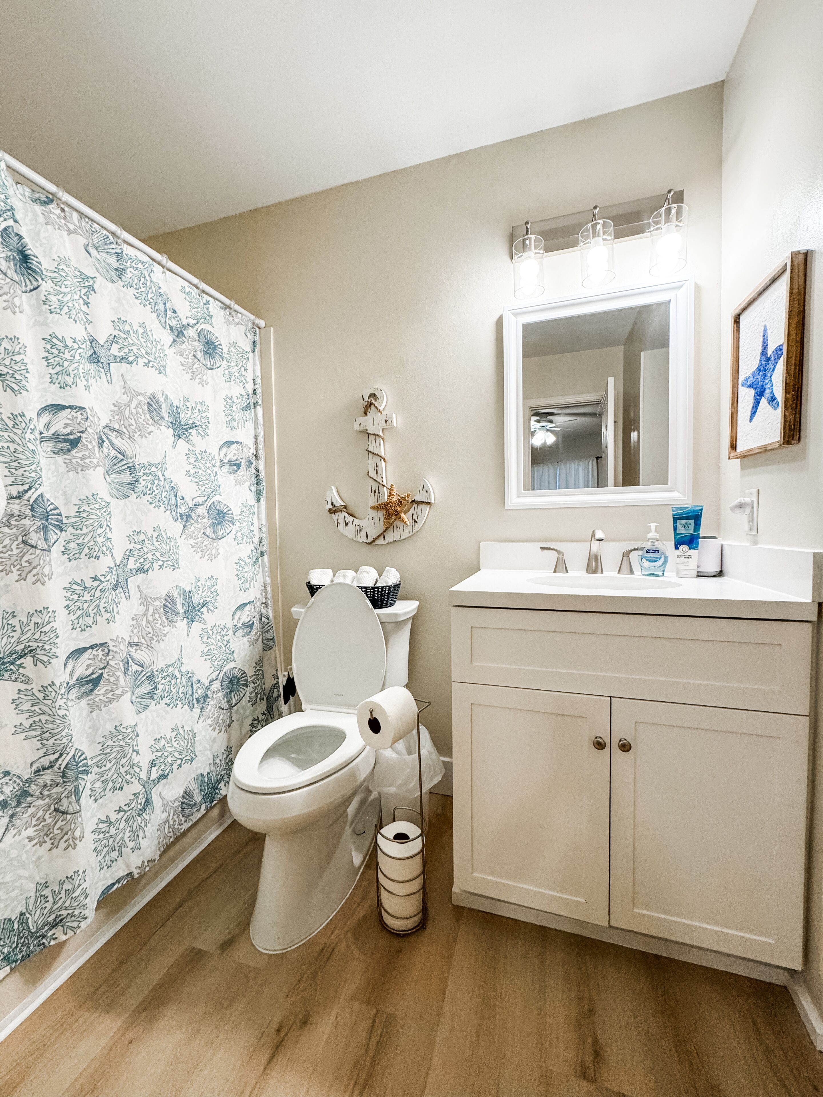 A bathroom with a toilet, sink, and shower curtain.