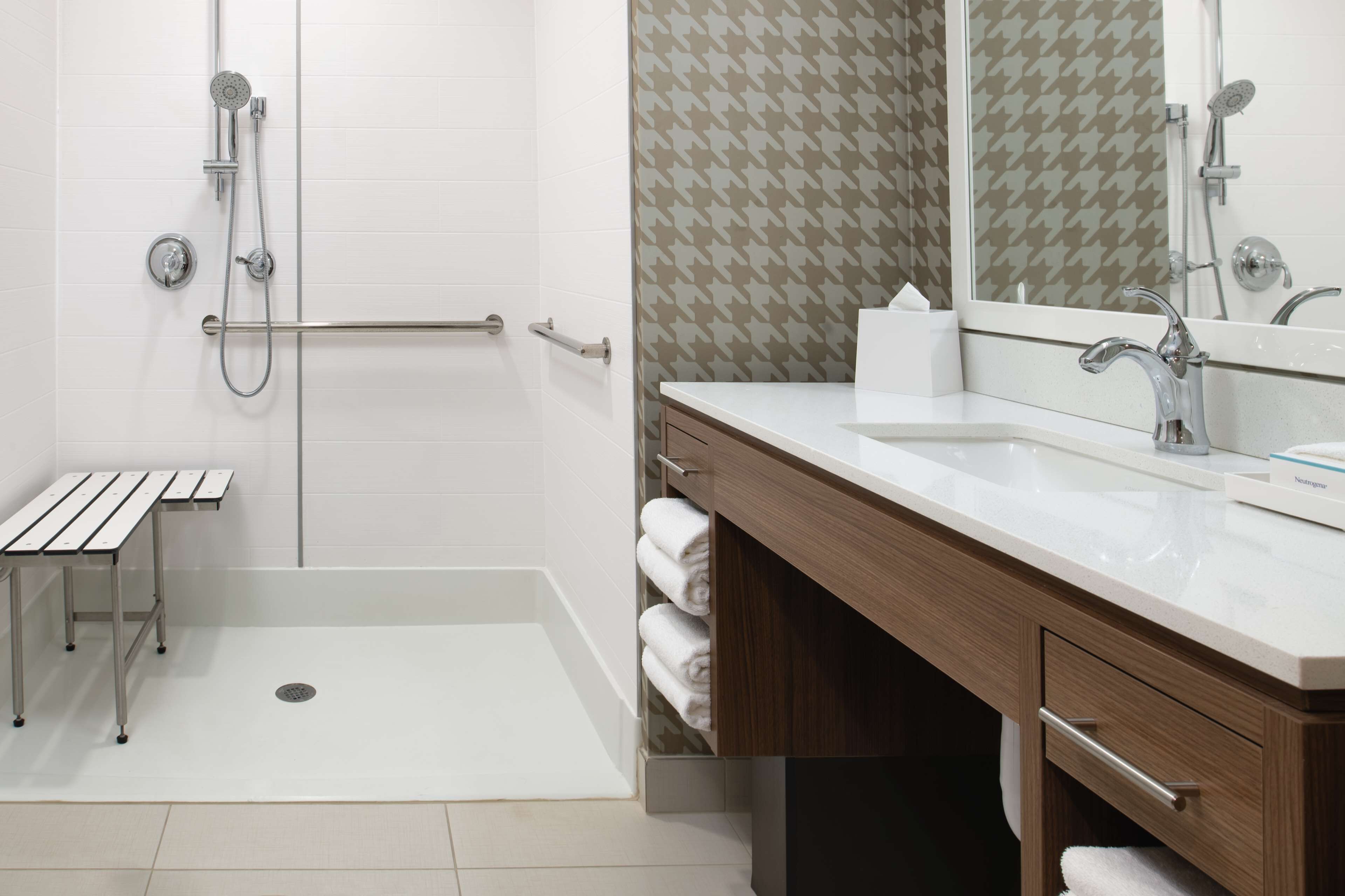 Une salle de bain moderne avec une douche à l’italienne, un meuble-lavabo et un miroir.