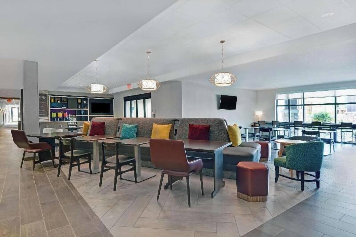 A spacious indoor area with a seating area, a bar, and a television screen.