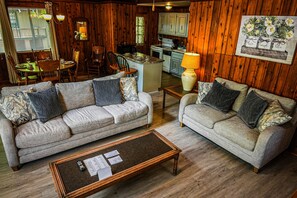 Cozy living room with a central island dining area, comfortable sofa, and kitchen in the background.
