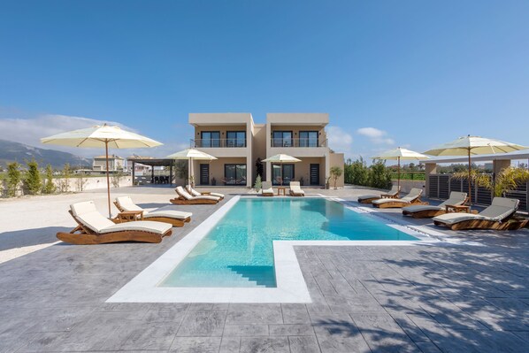 Piscine extérieure en saison, parasols, chaises longues