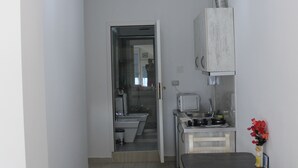 A compact kitchen with a dining area, a small refrigerator, a microwave, and a sink. - Studio in villa with amazing sea view (Vlorë)