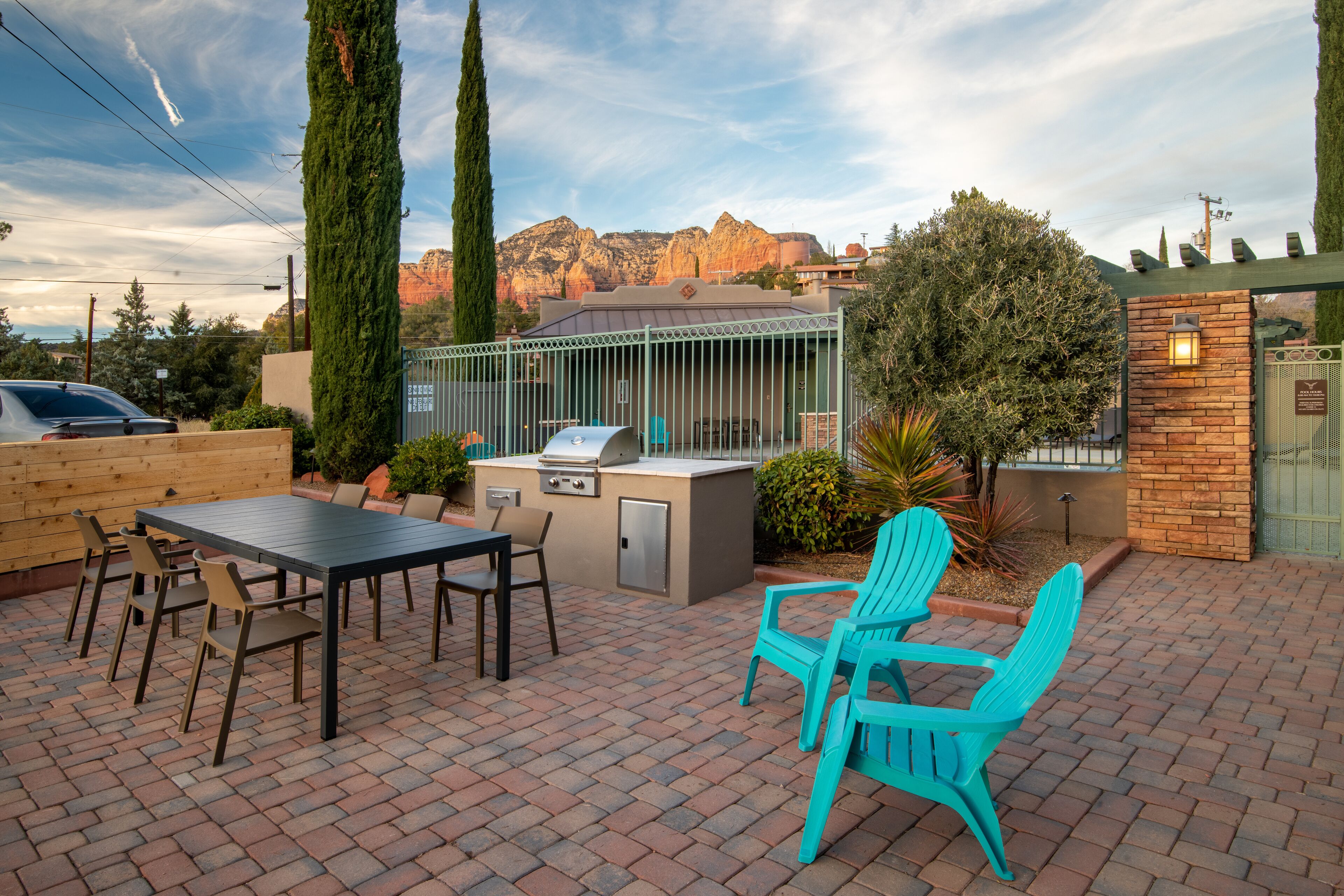 Un patio al aire libre con una parrilla, asientos y vistas a las montañas.