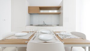 A modern kitchen with white cabinetry, a stainless steel sink, and a wooden countertop. - Rivazzurra Homes - 37 (Termoli)