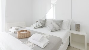 A modern, minimalist bedroom with a neatly made bed, a bedside table, and a nightstand. - Rivazzurra Homes - 37 (Termoli)