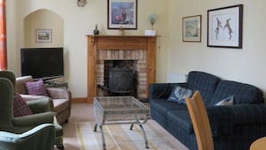 A living room with a fireplace, a television, and a sofa. - 2 bedroom accommodation in Duns (Duns)