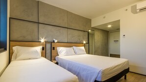 A hotel room with two beds, a wooden headboard, and a large mirror. - Ibis Ribeirao Preto Vila do Golf Hotel (Ribeirão Preto)