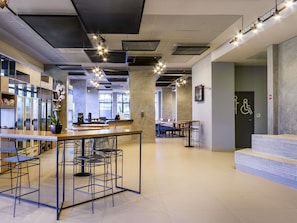 Un interior moderno con una zona de bar, asientos y un baño accesible para sillas de ruedas.