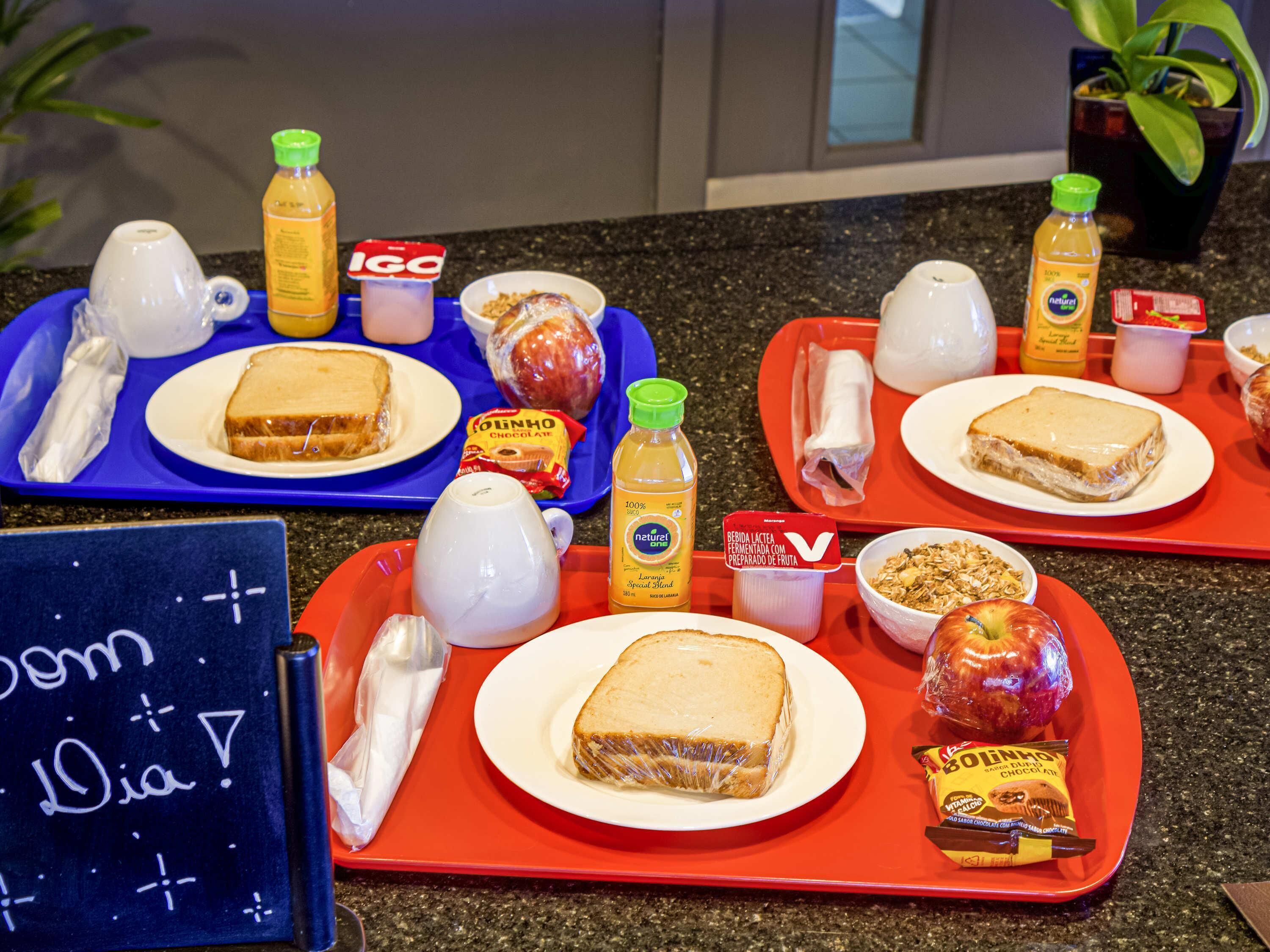 Un buffet de petit-déjeuner proposant une variété d’aliments et de condiments présentés sur des plateaux.