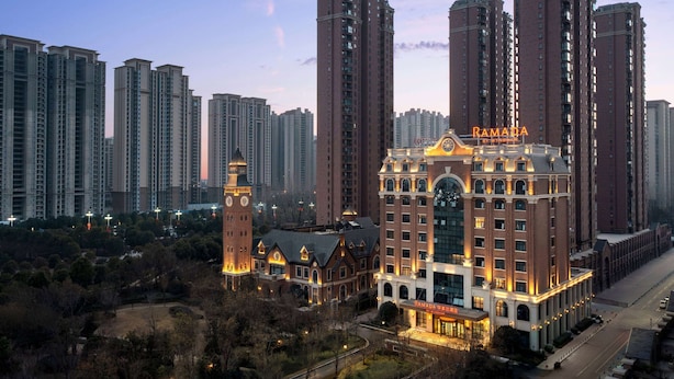 Un hotel con una torre de reloj, rodeado de edificios altos.