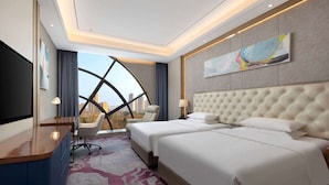 Una habitación de hotel con una cama grande, un escritorio y televisión.