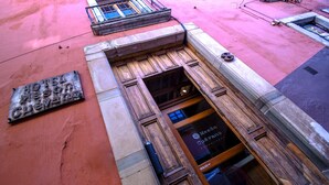 A hotel entrance with a wooden door and a metal sign above it. - Hotel Mesón Cuévano (Guanajuato)
