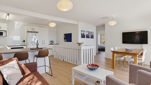 Um apartamento moderno com cozinha, sala de jantar e sala de estar.
