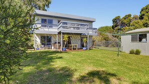A two-story house with a covered patio, a fenced yard, and a small shed. - Dolphin Dreaming - 16 Dolphin Avenue (CARRICKALINGA)