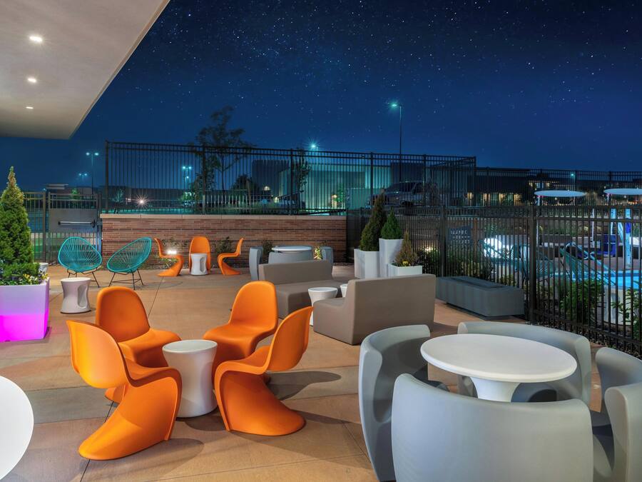 Un espace extérieur aménagé avec des meubles modernes, une piscine et une vue sur le ciel étoilé.