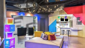 A modern lounge area with a sofa, bar, and seating. - Aloft by Marriott Denver North Westminster (Westminster)