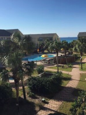 Relax by the resort's serene pool surrounded by lush greenery and palm trees.