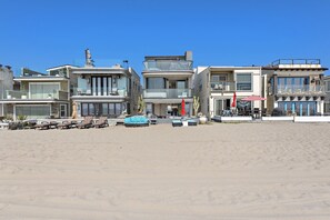 Une propriété située en bord de mer, dotée d’une architecture moderne, d’un espace piscine et d’un coin salon extérieur.
