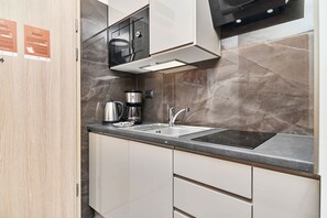 A modern kitchen with a built-in microwave, coffee maker, and a sink.