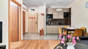 Une cuisine moderne équipée d’un four à micro-ondes, d’une cuisinière et d’un coin repas avec des chaises et une table.