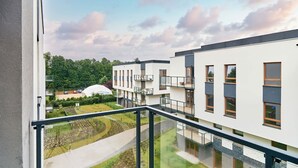 Un bâtiment moderne doté de nombreux balcons, d’une cour intérieure et d’une structure en forme de dôme en arrière-plan.