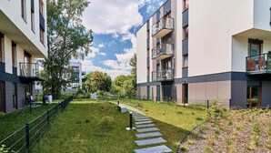 Un immeuble d’appartements moderne doté de balcons, d’un chemin pavé et d’une pelouse bien entretenue.
